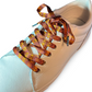 Beige sneaker with patterned shoelaces on a white background