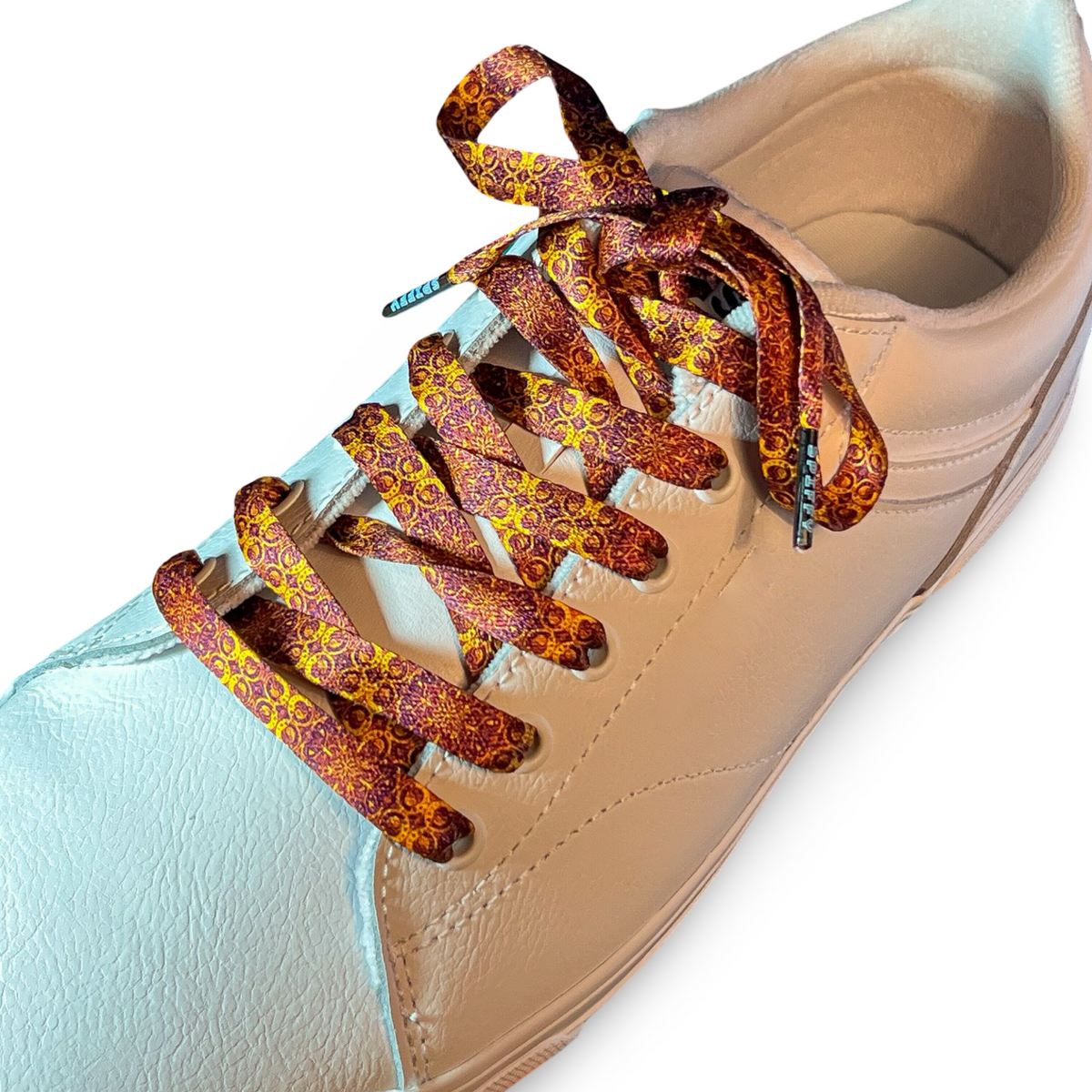 Beige sneaker with patterned shoelaces on a white background