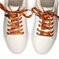 White sneakers with tapestry patterned laces on a white background