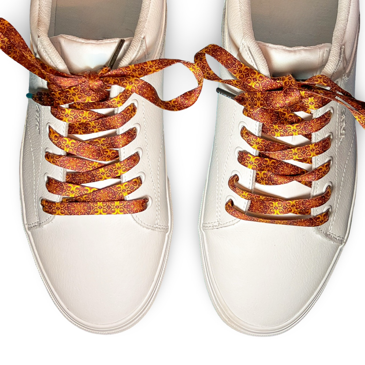 White sneakers with tapestry patterned laces on a white background