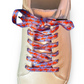 Beige sneaker with colorful and fun lobster shoelaces on a white background