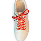 Beige sneaker with colorful heart shoelaces on a white background