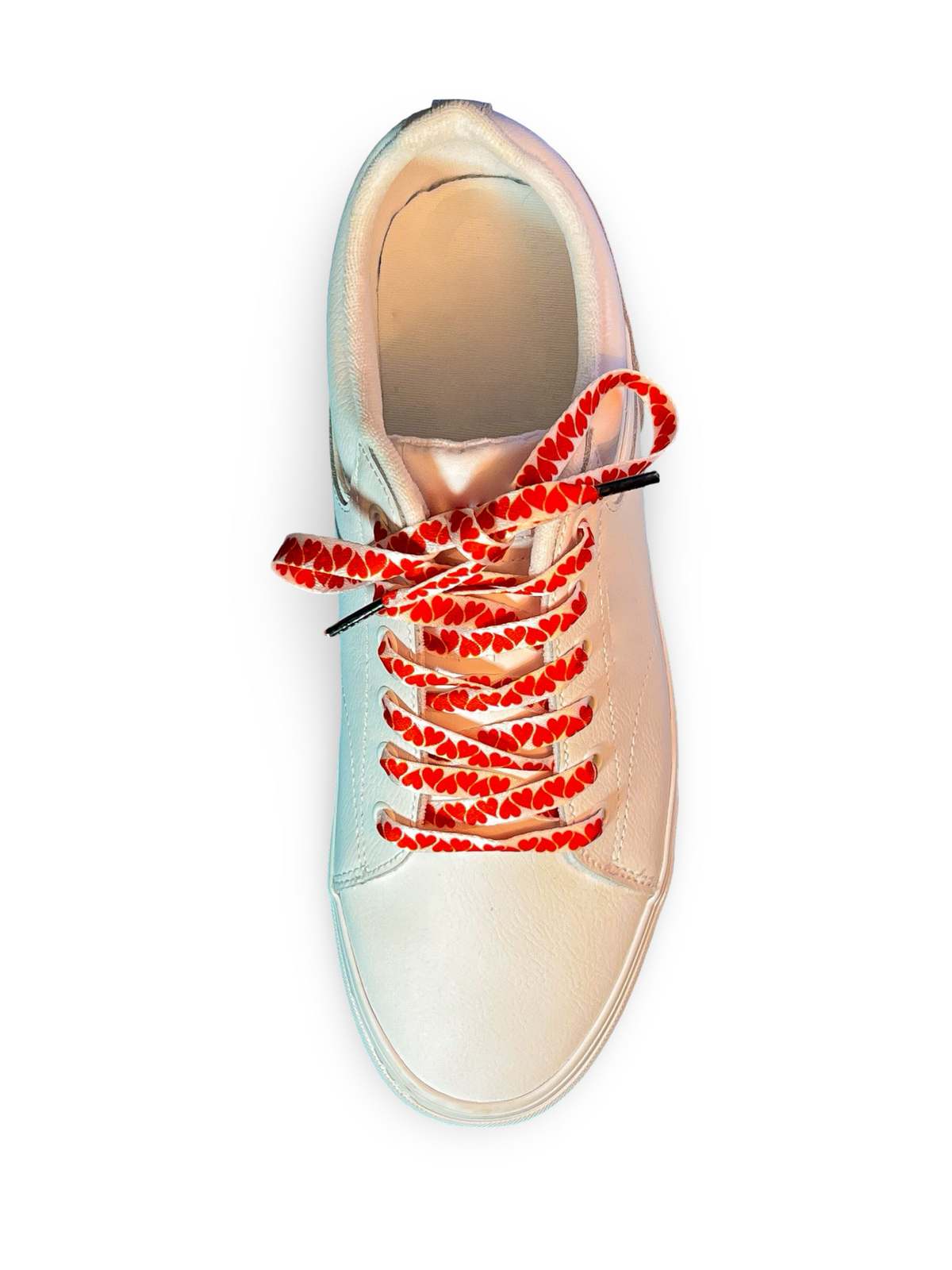 Beige sneaker with colorful heart shoelaces on a white background