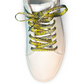 White sneaker with psychedelic smiley face patterned laces shoelaces on a white background