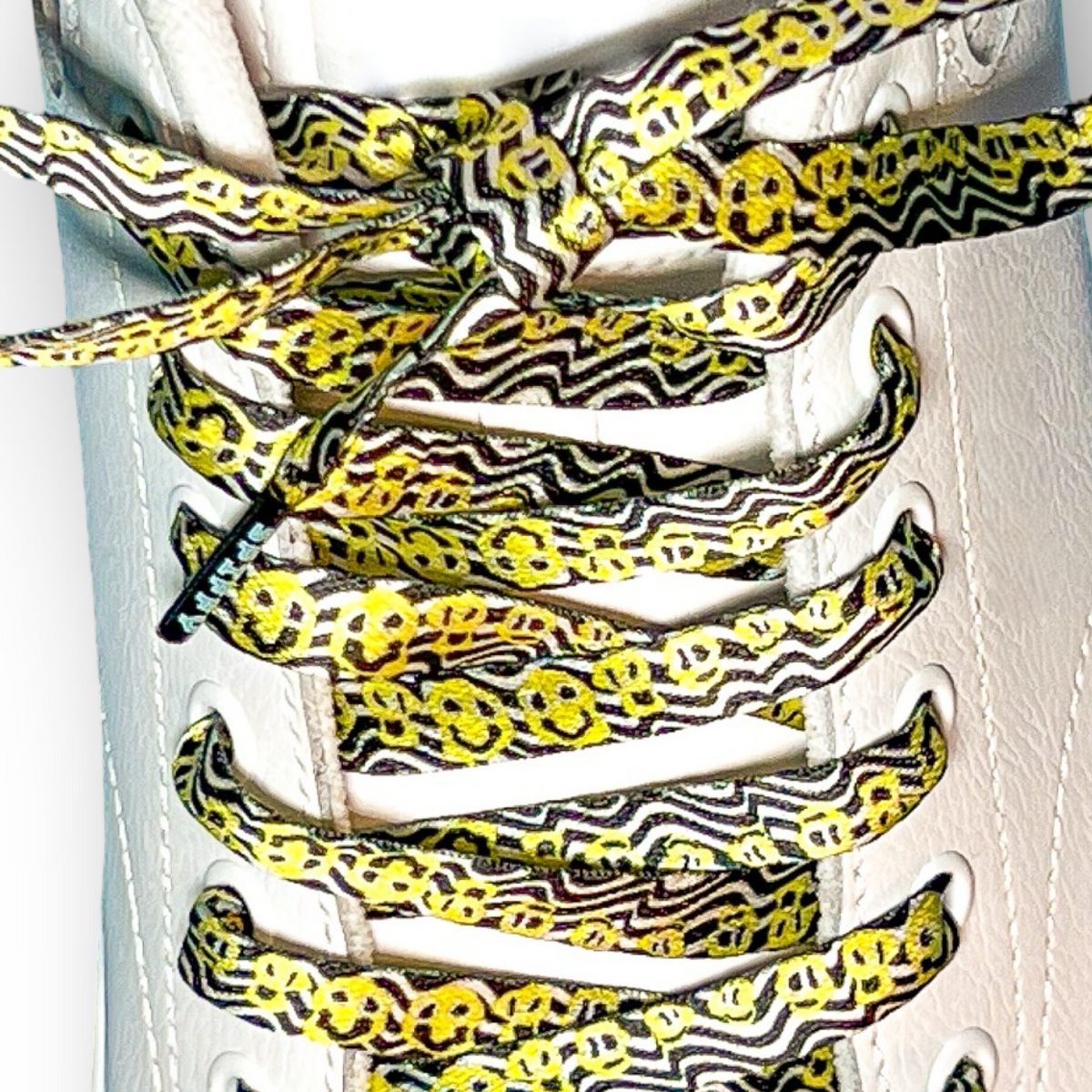 Shoe laces with black and yellow smiley face pattern on a white background