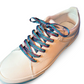 Beige sneaker with colorful zigzag laces on a white background