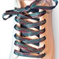 Colorful zigzag shoelaces on a white sneaker with a light gray background