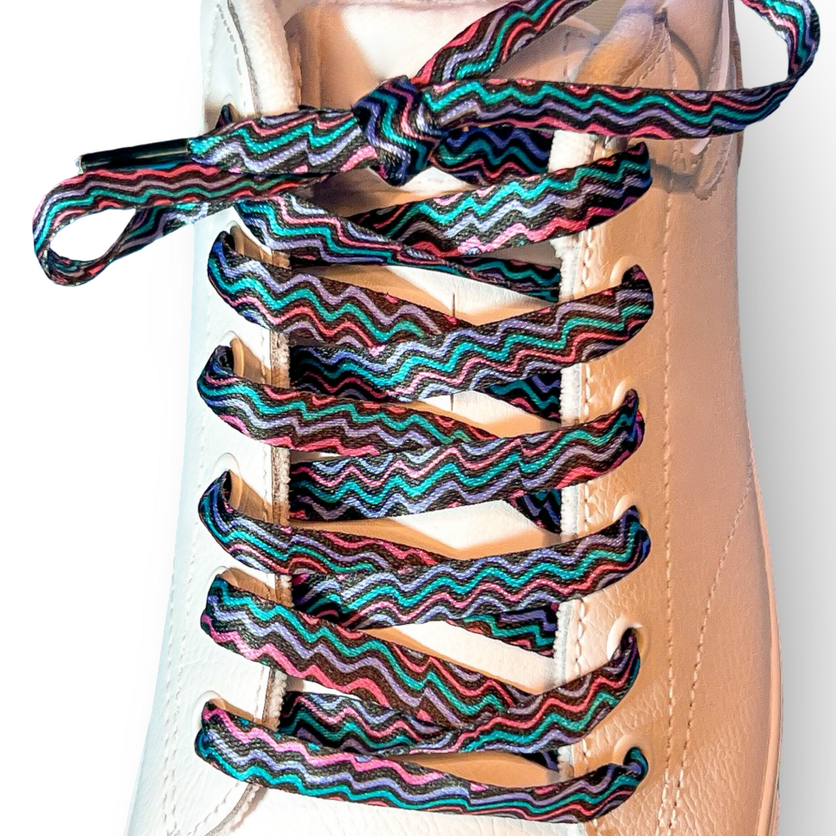 Colorful zigzag shoelaces on a white sneaker with a light gray background