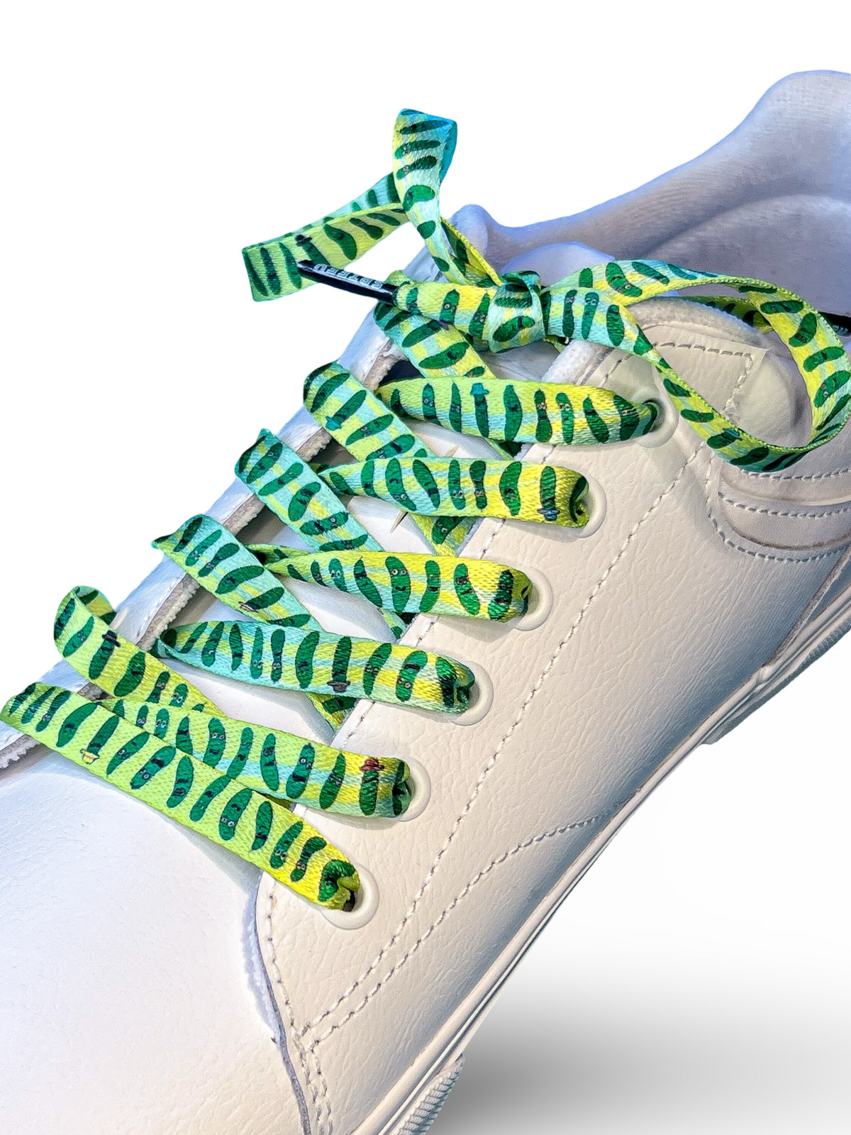White sneaker with green and yellow pickle laces on a white background