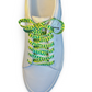 white sneaker with green and yellow pickle shoelaces on a white background