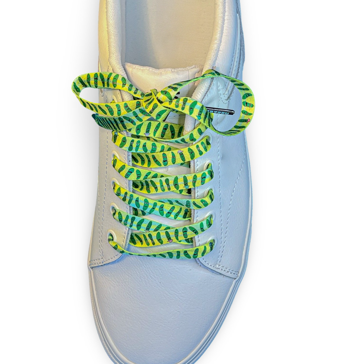 white sneaker with green and yellow pickle shoelaces on a white background