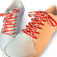 White and beige sneakers with colorful heart shoelaces on a white background