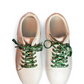 Pair of white sneakers with cow shoelaces on a white background