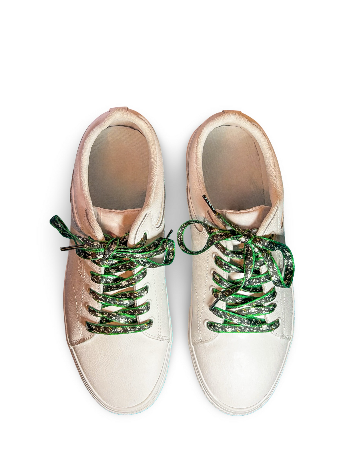 Pair of white sneakers with cow shoelaces on a white background