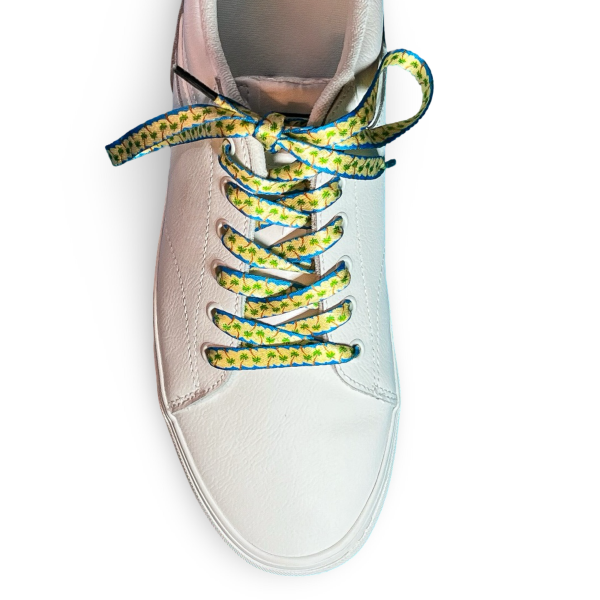 White sneaker with colorful palm tree shoelaces on a white background