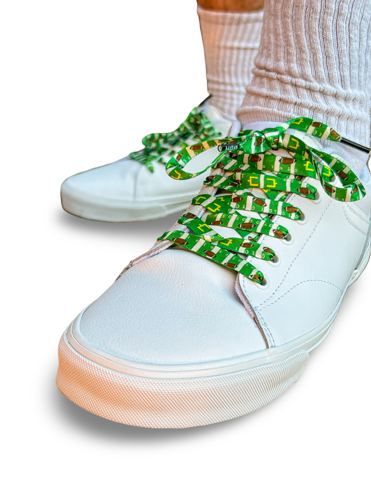 White sneakers with colorful football themed shoelaces on a white background
