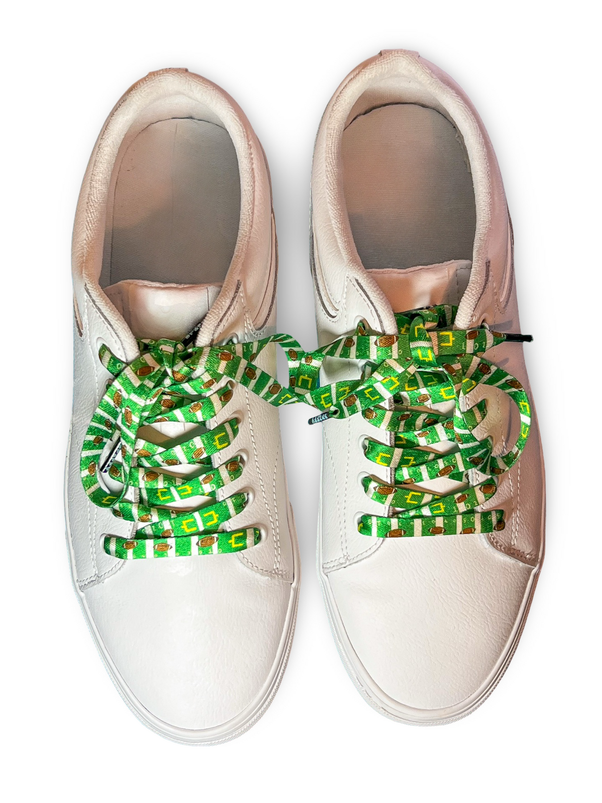 White sneakers with colorful football themed shoelaces on a white background