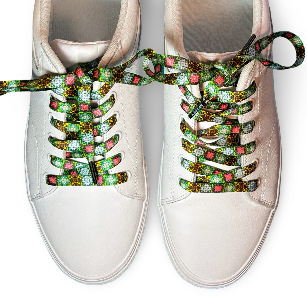 White sneakers with colorful, patterned laces on a white background