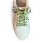 White sneaker with green patterned laces on a white background