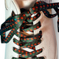 Close-up of a white shoe with rose printed shoelaces on a light background
