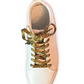 Rose gold sneaker with leopard print shoelaces on a white background