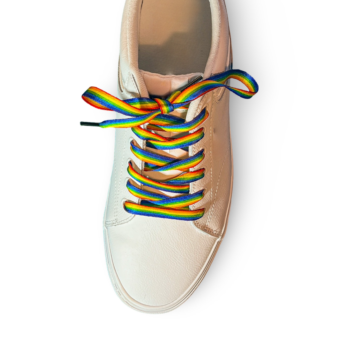 Beige sneaker with rainbow laces on a white background