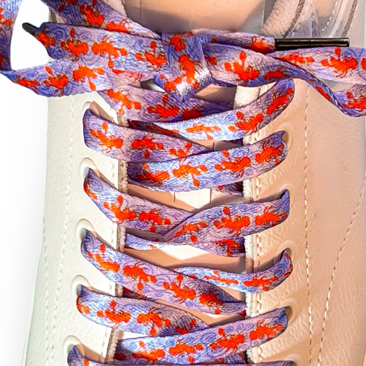 Colorful and fun lobster shoelaces on a beige sneaker with a white background