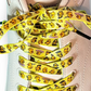 Yellow shoelaces with rubber ducks tied on a white sneaker