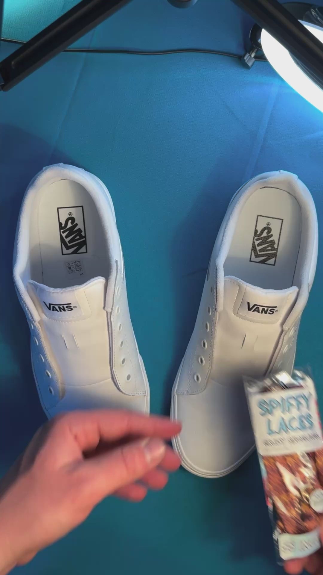 Tapestry printed shoelaces being laced up on a fresh pair of white sneakers