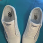 Colorful football themed shoelaces being laces up on a fresh pair of white sneakers