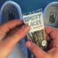 shoelaces with a psychedelic smiley face pattern being laced onto a fresh pair of white sneakers