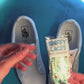 Zombie themed shoelaces being laced onto a fresh pair of white sneakers