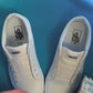 Tapestry shoelaces being laced up on a fresh pair of white sneakers