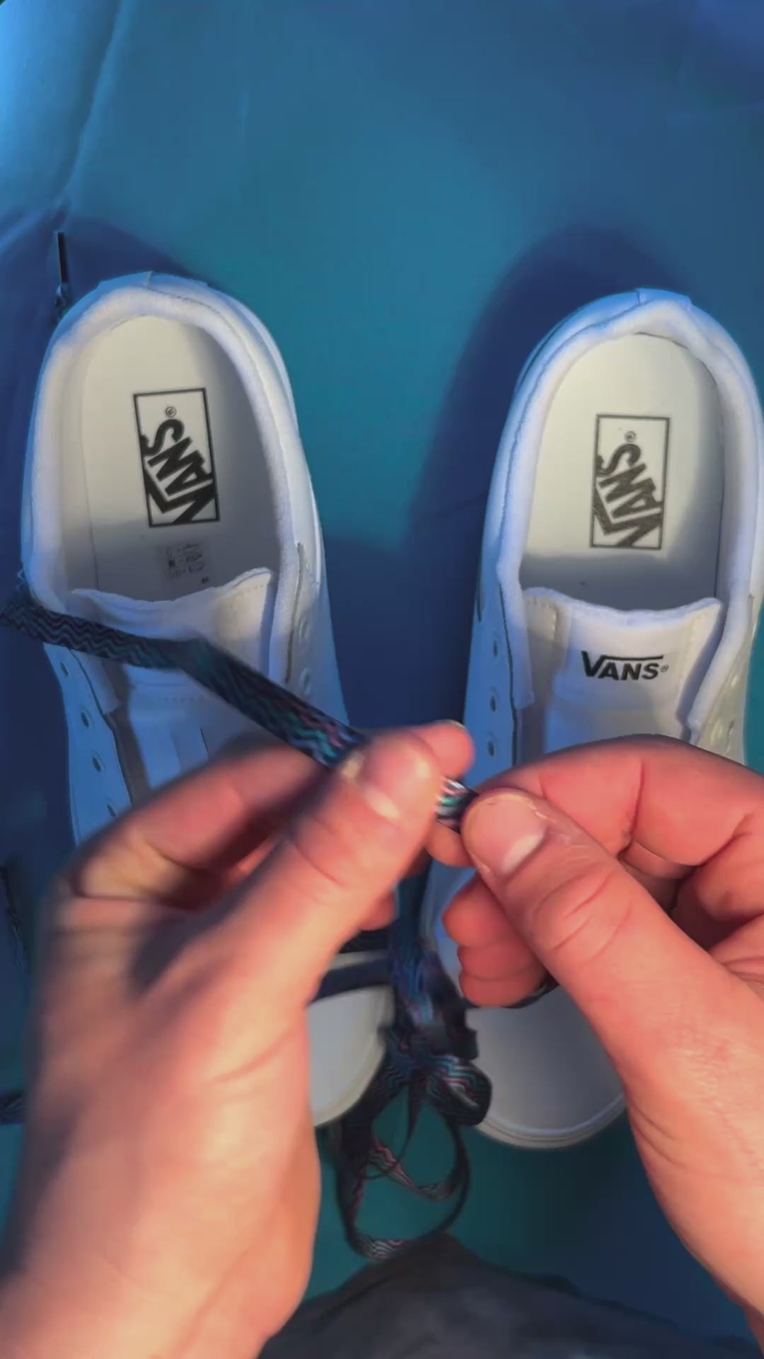 Colorful retro shoelaces being laced on on a fresh pair of white sneakers