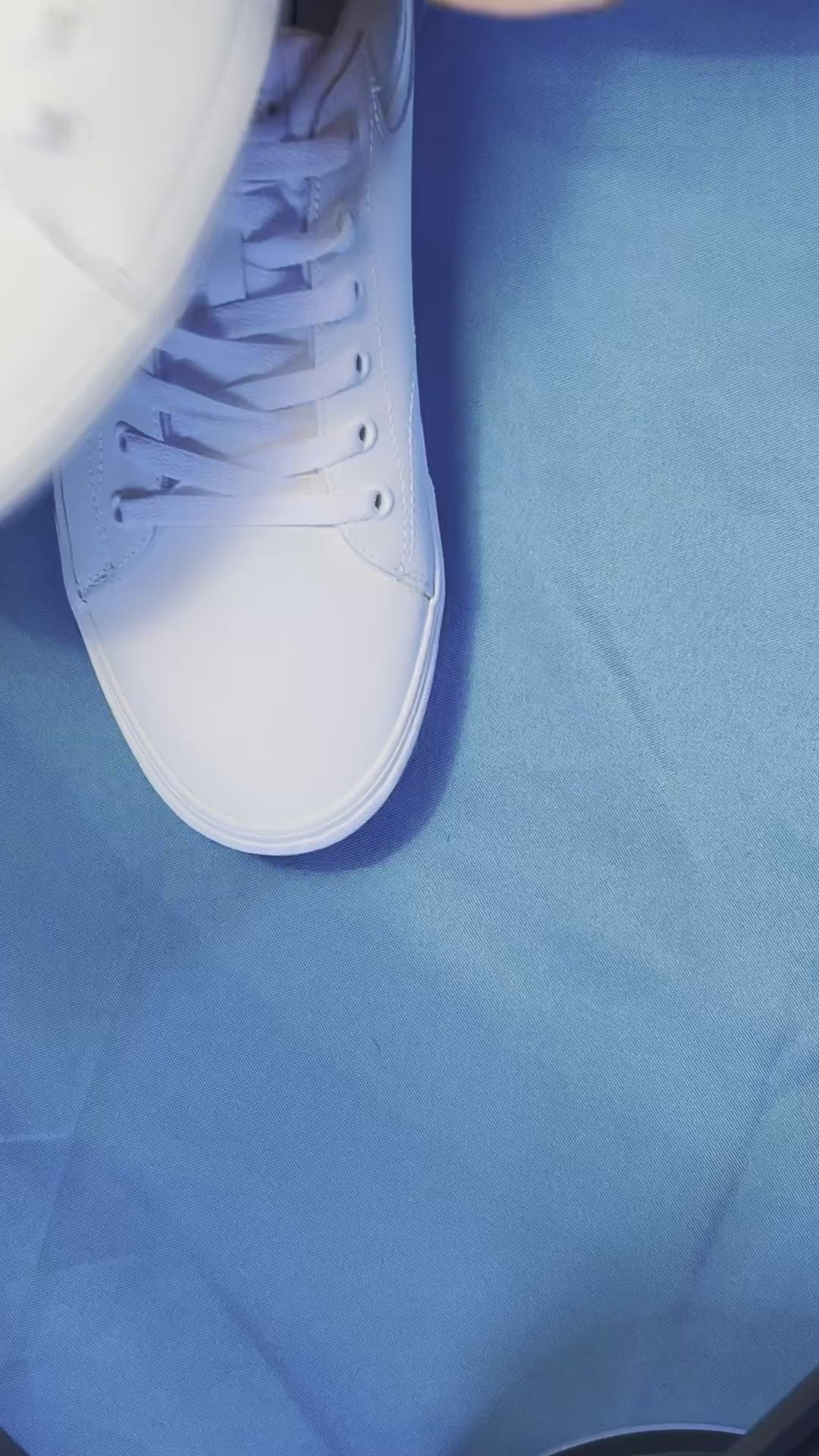 Green and yellow pickle patterned shoelaces being laced up on a fresh pair of white sneakers