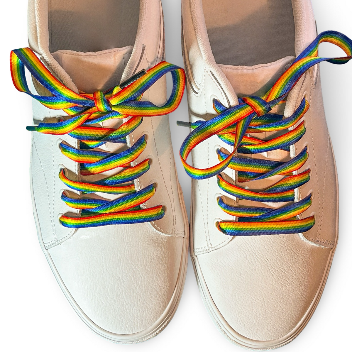Beige sneakers with rainbow laces on a white background